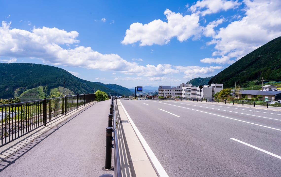 橋の風景写真。片側二車線の車道と歩道を区切る柵が写っている。